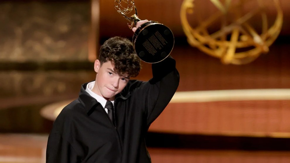 Owen Cooper holds up an Emmy on stage at the Emmy