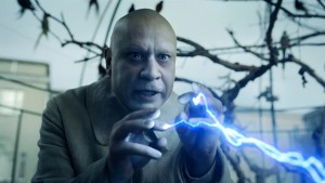 Fred Armisen's Fester Addams shoots electricity out of his fingers in an aviary